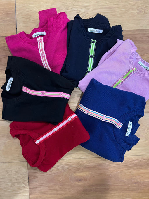 Colorful preppy merino wool cardigans on a wood background from Noyac Knits