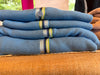 Stack of Allison Crop Cardigans in Egyptian cotton knit in Brooklyn, New York by Noyac Knits — showing the signature grosgrain ribbon trim and natural shell buttons.