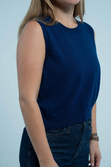 woman wearing cobalt blue sleeveless sweater shell on plain background