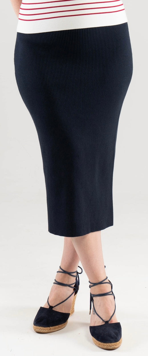 Woman wearing a Noyac Knits navy ribbed knit midi skirt and navy espadrilles on a white background