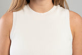 close up of white crew neck ribbed sleeveless top worn by a woman on a gray background