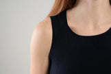 Close up of neckline and traveling rib pattern on Noyac Knits navy scoop neck tank in soft and lightweight ecoviscose on plain background