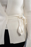 Close-up of a white ribbed knit cardigan with a self-tie