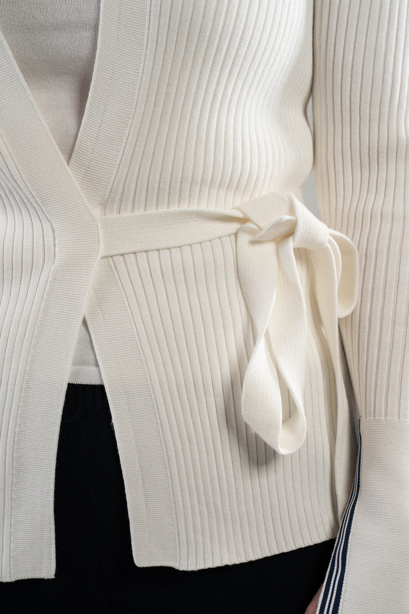 Close-up of a white ribbed knit cardigan with a self-tie