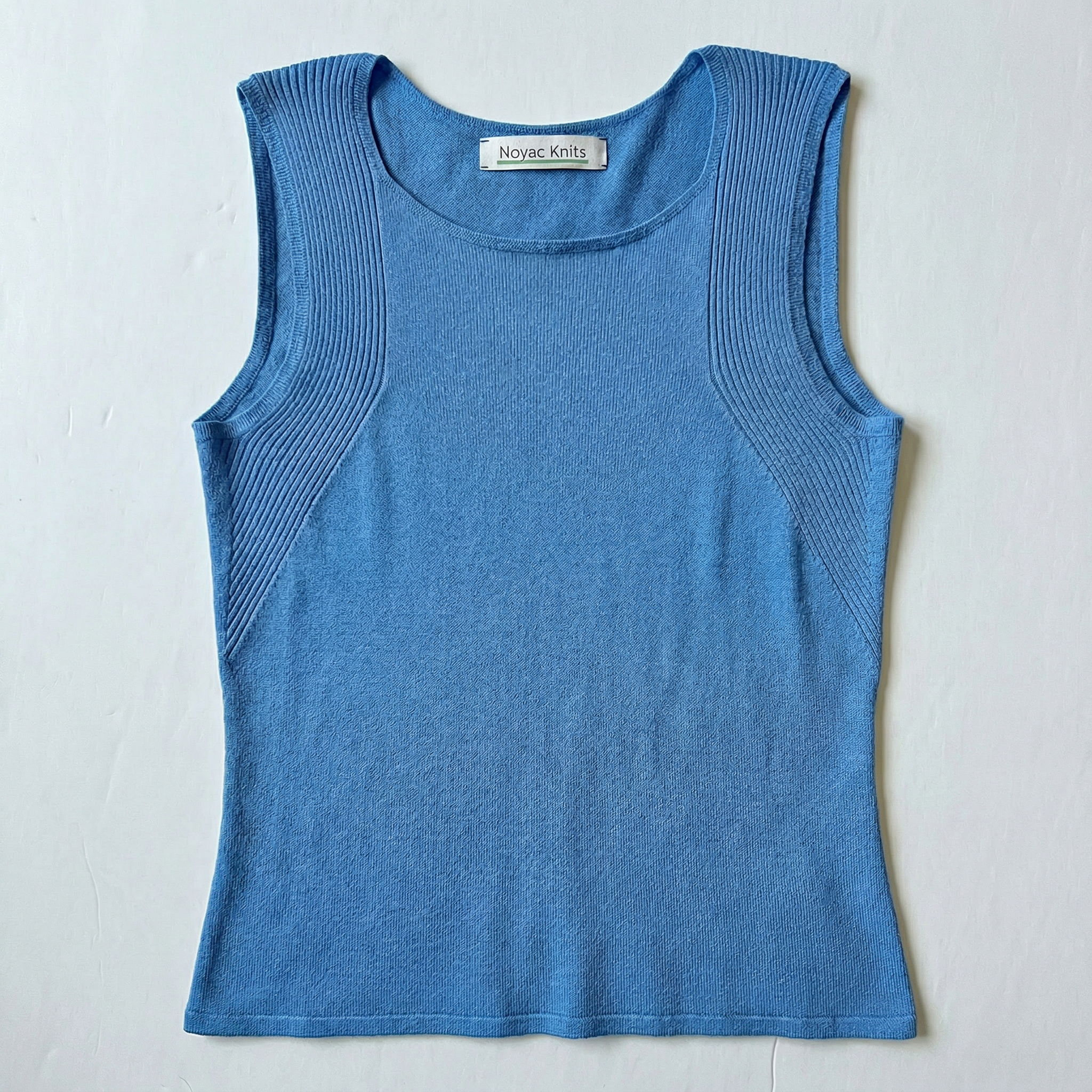 Flat lay photo of Noyac Knits featherweight scoopneck tank with traveling rib pattern around arms in lightweight environmentally sustainable ecoviscose in light blue