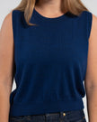 Close up of woman wearing Noyac Knits cobalt blue crop sleeveless sweater shell in premium soft merino wool and jeans on plain background