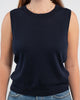 Close up of woman wearing Noyac Knits classic sleeveless sweater shell in navy knit in ultra soft premium lightweight merino styled with jeans, pearl choker on plain background.  This versatile piece works well alone, over a blouse, under a matching classic cardigan or under a blazer.