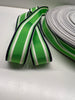Close up of grosgrain ribbon with bright green center stripe inside thinner white, bright green and navy stripes on plain background.