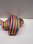 Close up of rainbow striped ribbon with light pink, dark pink, light blue, teal blue, light green, cobalt blue, and yellow stripes on  a white background