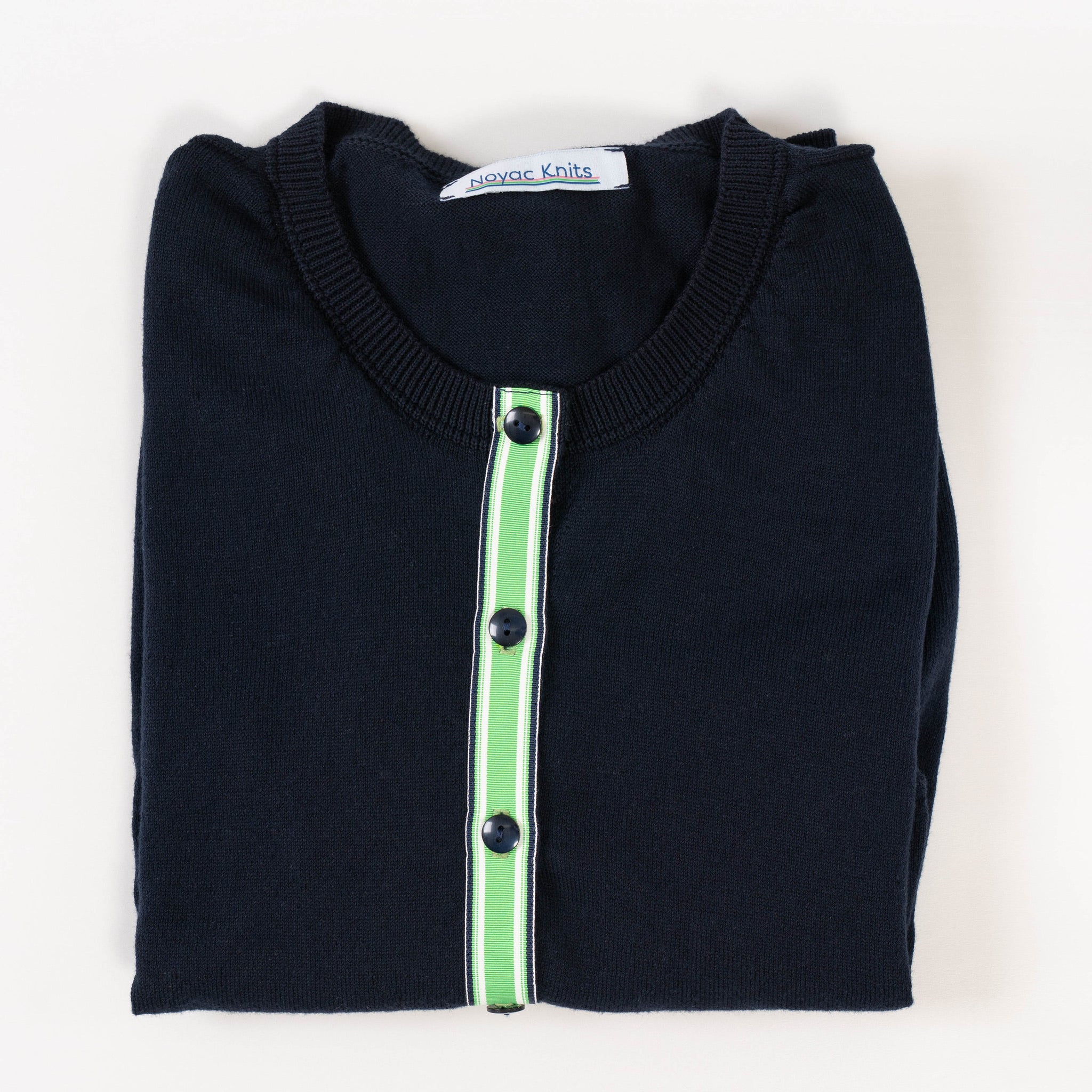 Folded navy ribbon cardigan from Noyac Knits trimmed with signature green, white, and navy striped ribbon trim and navy buttons in premium Egyptian cotton