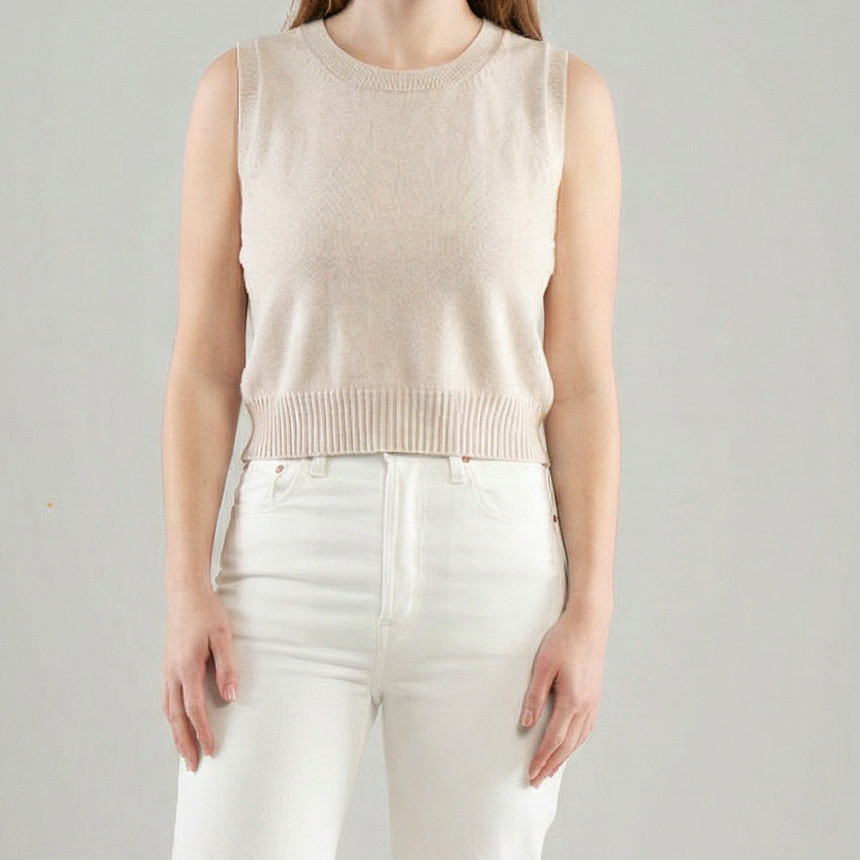 Womab wearing a Noyac Knits sleeveless crew neck crop sweater in lightweight cotton and white pants on a white background