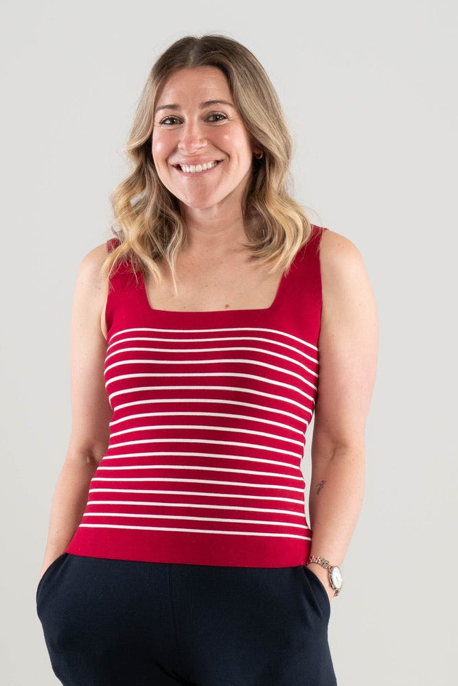 Woman wearing a Noyac Knits Breton square neck sleeveless tank in red s with white stripes in environmentally sustainable ecoviscose and navy  pants on a white background
