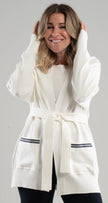 Woman wearing a white Noyac Knits long belted cardigan with navy and white striped ribbon trimmed pockets in cozy soft ecoviscose  on a white background