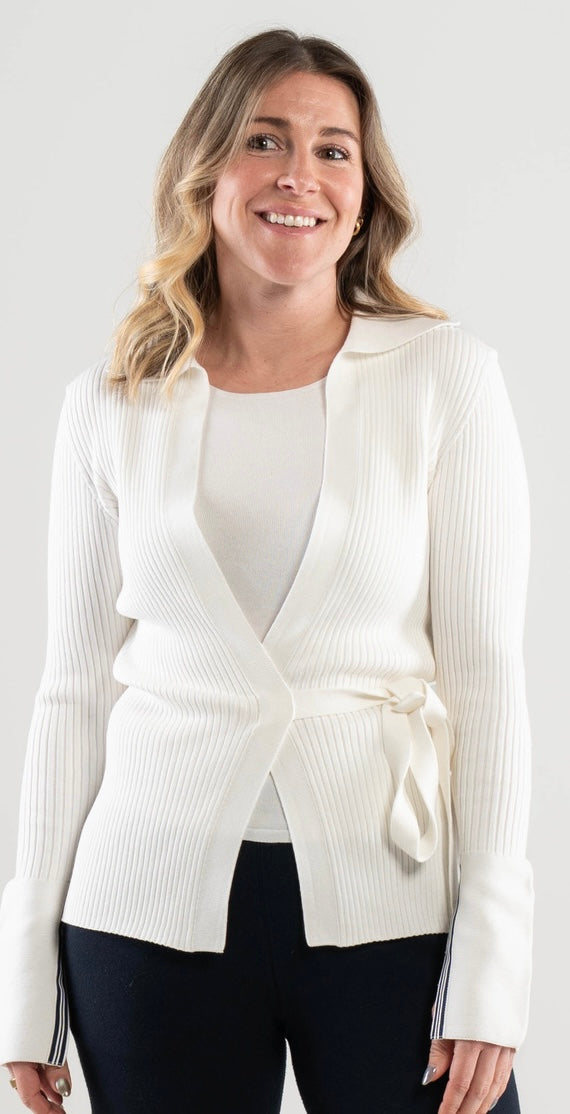 Woman wearing a Noyac knits white ribbed knit  wrap cardigan over a featherweight white scoop neck top in environmentally sustainable ecoviscose on  a plain background