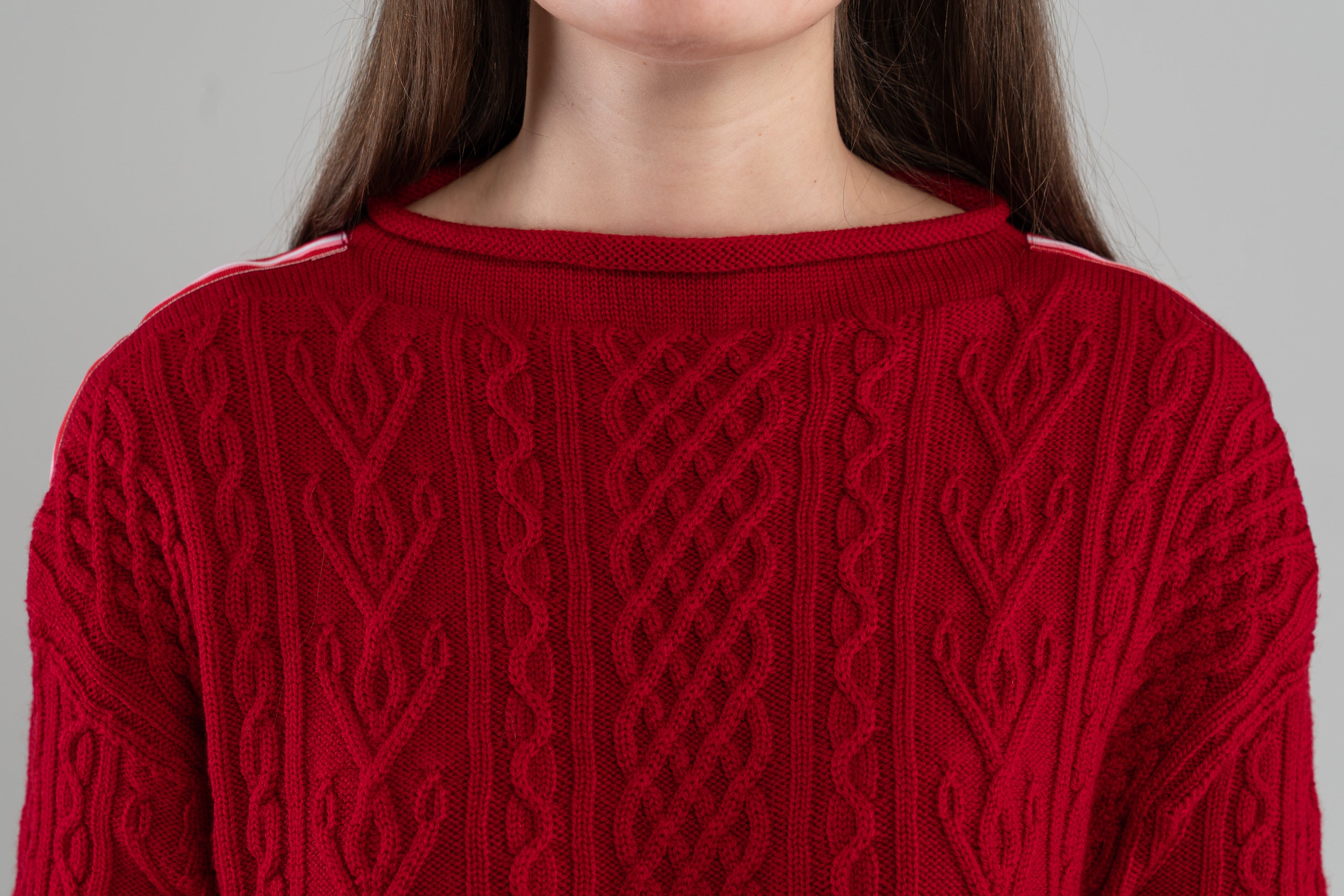close up of red Noya Knits boatneck pullover sweater showing beautiful cable knit  pattern - knit in premium, soft merino wool